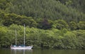 Caledonian canal with sailboat and forest in Scotland Royalty Free Stock Photo