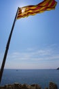 Calella de Palafrugell, Spain, May 1, 2020 - Catalan flag on flagpole over sea