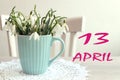 Calendar for April 13: the name of the month April in English, the numbers 13, a bouquet of snowdrops on the background of a