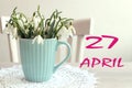 Calendar for April 27: the name of the month April in English, the numbers 27, a bouquet of snowdrops on the background of a