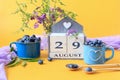 Calendar for August 29 :the name of the month of August in English, cubes with the number 29, blueberries in blue cups, bouquets Royalty Free Stock Photo