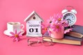 Calendar for August 1 : the name of the month of August in English, the numbers 0 1, a cup of tea, books, a bouquet of pink Royalty Free Stock Photo