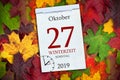 Calendar with autum leaves and the german words for wintertime and time change with return to standard time