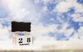 Calendar box with blackboard for entering text,February 28 days Place on wooden table,bright blue sky background, copy space and Royalty Free Stock Photo