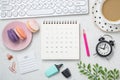 Calendar with clock, coffee cup and candy on office table Royalty Free Stock Photo