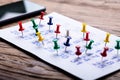 Calendar With Colorful Push Pins Over Wooden Desk