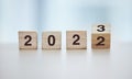 Calendar, 2023 countdown and wooden blocks on empty table in grey studio background for goals or resolution. New year