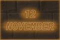 Calendar date on the background of an old brick wall. 12 november written glowing font. The concept of an important date or