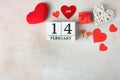 Calendar with date February 14, small gift and lot of red hearts