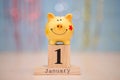 Calendar date of Financial Year start, 1st january with piggy bank on blue background. Winter time. Royalty Free Stock Photo