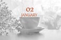 Calendar date on light background with porcelain white tea pair and white gypsophila with copy space. January 2 is the second