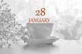 Calendar date on light background with porcelain white tea pair and white gypsophila with copy space. January 28 is the twenty-