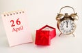 Calendar date on light background with red gift box with ring and alarm clock with copy space. Royalty Free Stock Photo