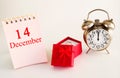 Calendar date on light background with red gift box with ring and alarm clock with copy space. December 14 is the fourteenth  day Royalty Free Stock Photo