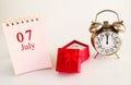 calendar date on light background with red gift box with ring and alarm clock with copy space. Royalty Free Stock Photo