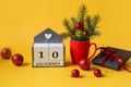 Calendar for December 10 : name of the month in English, number 10 ,Christmas composition in red cups, Christmas balls , gift in