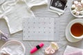 Calendar with the expected date of birth of baby, different baby clothes and ultrasound scan, pregnancy and birth concept