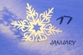 Calendar for January 17: decorative snowflake on the snow close-up, numbers 17, name of the month January in English