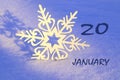 Calendar for January 20: decorative snowflake on the snow close-up, numbers 20, name of the month January in English