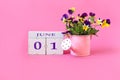 Calendar for June 1 : the name of the month of June in English, cubes with the numbers 0 and 1, a bouquet of viola in a pink Royalty Free Stock Photo
