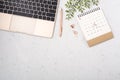 Calendar with laptop on white quartz background Royalty Free Stock Photo
