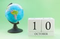 Calendar made of wood on a light green background, 10 day of the month October, autumn 10th day