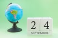 Calendar made of wood on a light green background, 24 day of the month September, autumn 24th day