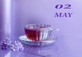 Calendar For May 2: The First Spring Flowers Near A Mug Of Tea On A Pastel Background, The Name Of The Month May In English,
