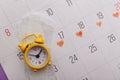 Calendar, menstrual pads and yellow alarm clock close-up