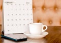 Calendar  mobile  coffee cup Placed on an old wooden table is a planning idea for success. Royalty Free Stock Photo