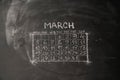 calendar month March is painted on a chalkboard.