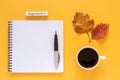 Calendar month September, cup of coffee, blank notepad with pen and autumn leaves on yellow background. Mockup Top view Flat lay
