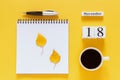 Calendar November 18 cup of coffee, notepad with pen and yellow leaf on yellow background Royalty Free Stock Photo