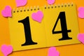 Calendar with number 14 on a yellow background with pink hearts mess on bright yellow background