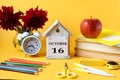 .Calendar for October 16 : decorative house with the name of the month in English and the number 16, a bouquet of dahlias, books,