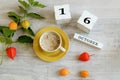 Calendar for October 16 : the name of the month in English, cubes with the number 16, a yellow cup with hot coffee, branches of