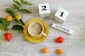 Calendar for October 21 : the name of the month in English, cubes with the number 21 , a yellow cup with hot coffee, branches of