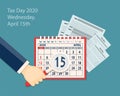 Calendar page April 2020, hand and 15th is in magnifier for tax day