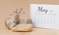 Calendar-page for the full month: May 2021 .Composition of dried flowers among stones, white notebook with a spiral on a beige Royalty Free Stock Photo