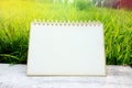 Calendar page on white wooden table on nature green field grass