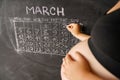 Calendar of the pregnant woman the month March counting days with a calendar for the birth of a child on a chalkboard. The concept