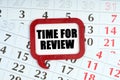 On the calendar, a red plaque with the words inside - TIME FOR REVIEW Royalty Free Stock Photo
