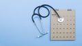 Calendar, stethoscope, on a blue background, health care concept.