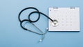 Calendar, stethoscope, on a blue background, health care concept.