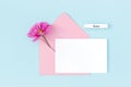 Calendar summer month June, white blank card, pink envelope and flowers on blue background. Minimal style. Top view Flat lay