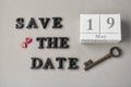 Calendar, vintage key and phrase SAVE THE DATE composed with letters on grey background