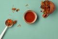 Calendula dried herbs in orange craft cup with honey on blue background. Royalty Free Stock Photo