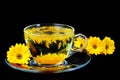 Calendula tea in transparent cup isolated on black Royalty Free Stock Photo