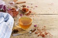 Calendula teacup With dried marigold flowers scattered on an old wooden table with copy space for your text - Top view