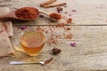 Calendula teacup With dried marigold flowers scattered on an old wooden table with copy space for your text - Top view